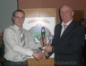 Antrim County Manager Liam 'Baker' Bradley presents Reserve Footballer of the year to Damien Mc Gaughey